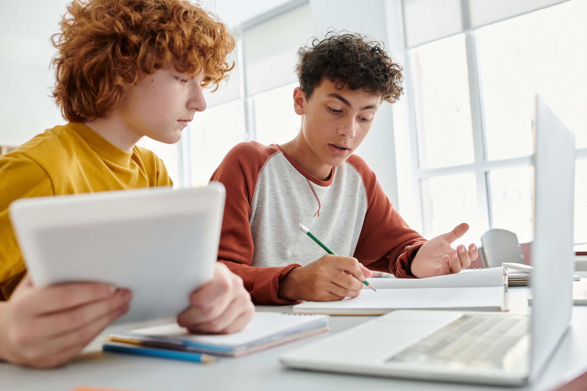 Teenage students collaborating on a project in a bright and modern classroom at school